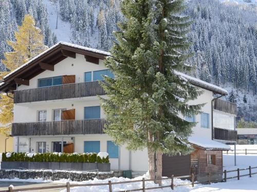 a house in the snow with a tree at Apartment Hutter by Interhome in Churwalden