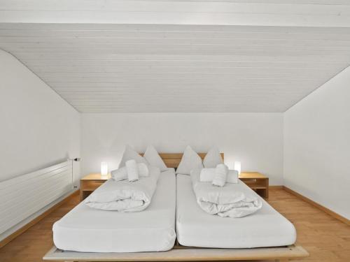 two beds in a room with white walls at Apartment Hutter by Interhome in Churwalden