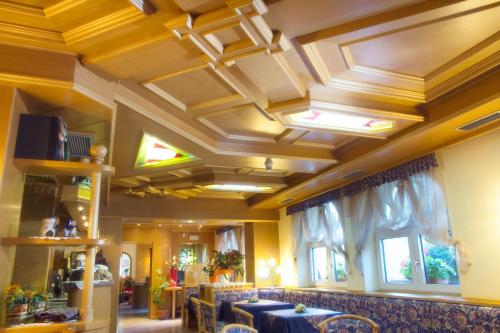 a dining room with a table and chairs and a ceiling at Hotel Michela in Malè