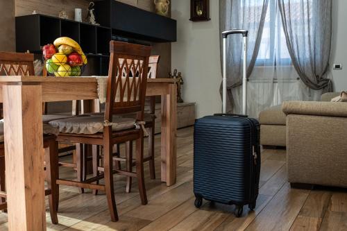 a living room with a table with a suitcase next to a table with a dining at a casa di Ma Gi in Ciampino