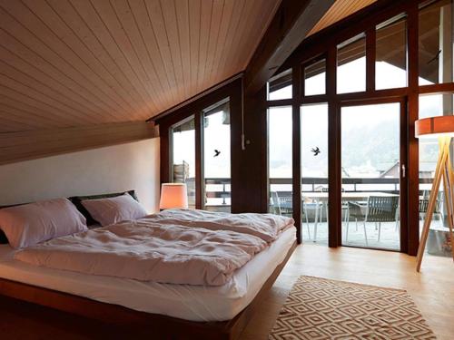 a bedroom with a large bed and large windows at Apartment Am Dürrbach 2-244 by Interhome in Engelberg