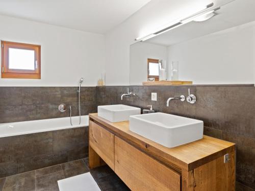 a bathroom with two sinks and a bath tub at Apartment Kulm 2 by Interhome in Valbella