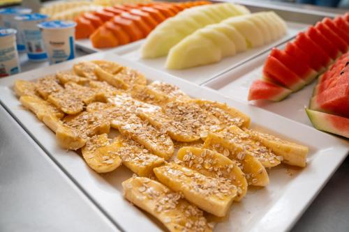 a white plate of food with fruit on it at Pousada Pedra da Ilha in Penha