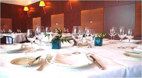 a table with wine glasses and plates and utensils at Hôtel Savoie Léman in Thonon-les-Bains