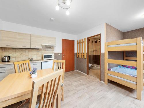 a kitchen and dining room with a table and bunk beds at Holiday Home Jílové by Interhome in Jílové