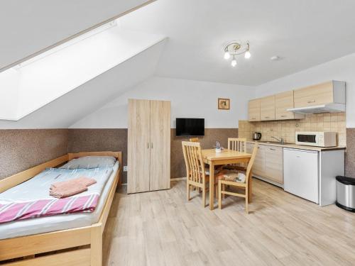 a bedroom with a bed and a table and a kitchen at Holiday Home Jílové by Interhome in Jílové