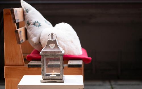 a lantern sitting next to a chair with a pillow at Abbraccio Alpino in Pila