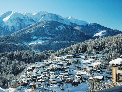 a village covered in snow with mountains in the background at Apartment Panorama da muntognas by Interhome in Trin