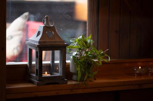 a lantern sitting on a window sill next to a plant at Abbraccio Alpino in Pila