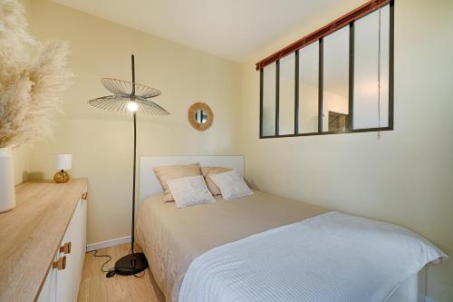 a small bedroom with a bed and a window at Le Molière des Bords de Seine - 15 min de Paris in Asnières-sur-Seine