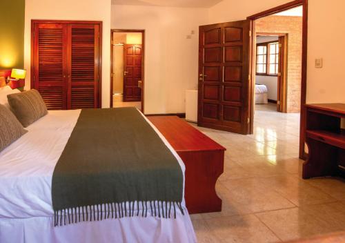 a bedroom with a bed and a dresser in a room at El Leñador by DOT Cabana in Puerto Iguazú