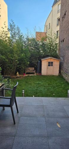 een bankje op een terras voor een tuin bij Maison Les Vallées in La Garenne-Colombes