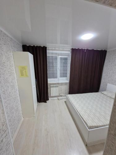 Cette chambre comprend deux lits et un réfrigérateur. dans l'établissement 2х-ком апартаменты в центре города Kvant, à Petropavlovsk-Kamtchatski