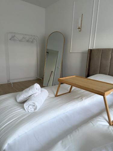 a room with a bed with towels and a mirror at HomeyHome Strasbourg in Schiltigheim