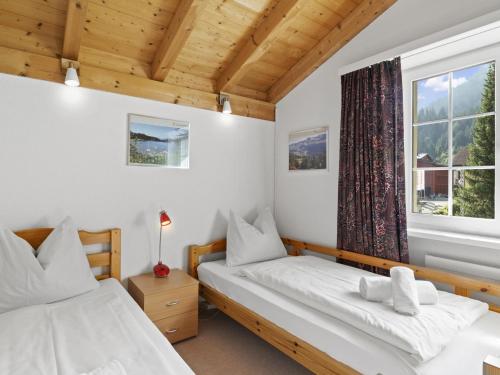 two beds in a room with a window at Apartment van der Meij by Interhome in Churwalden