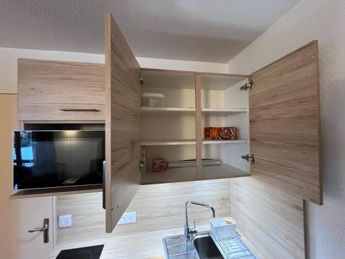 - une cuisine avec des placards en bois et un évier dans l'établissement STUDIO 4 personnes - 19m2 plus terrasse- Le pluton, à Les Deux Alpes