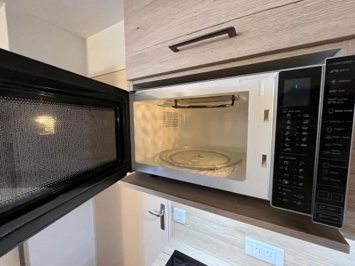 un four micro-ondes installé au-dessus d'un comptoir de cuisine dans l'établissement STUDIO 4 personnes - 19m2 plus terrasse- Le pluton, à Les Deux Alpes