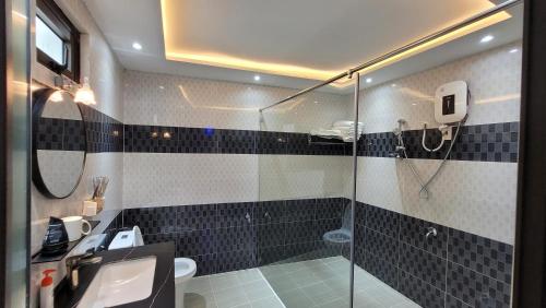 a bathroom with a glass shower and a sink at Villa Homestay Thanh Hiền in Ho Tram