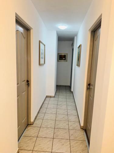a hallway with two doors and a tile floor at Casa Montana in Predeal