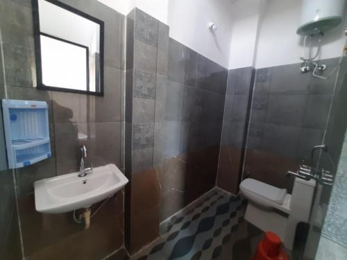 a bathroom with a sink and a toilet and a window at Gladden Villa in Udaipur