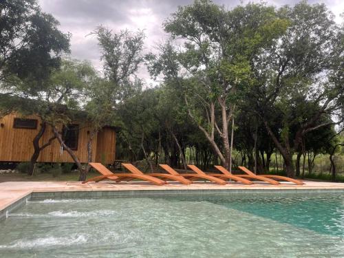a group of chairs sitting next to a swimming pool at Ser Monte Hospedaje in La Población