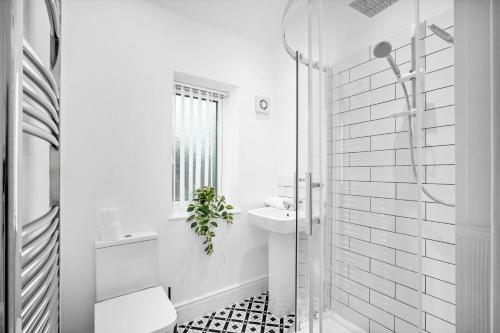 a white bathroom with a sink and a shower at Two Bedroom Apartment - On Street Parking Available - Netflix - Wifi - Top Rated - 311M in Birmingham