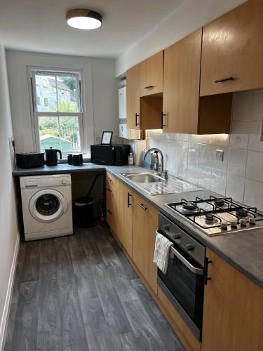 a kitchen with a stove and a washing machine at Central Chic 3 bed, Great Location in Winchester