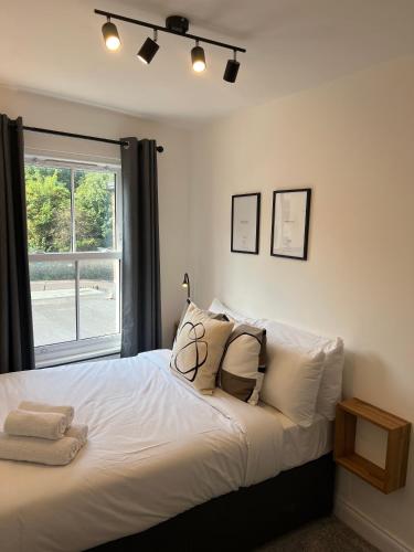 a bedroom with a large white bed with a window at Central Chic 3 bed, Great Location in Winchester