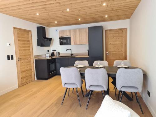 une cuisine et une salle à manger avec une table et des chaises dans l'établissement Appartement 6 à 8 voyageurs, à Huez