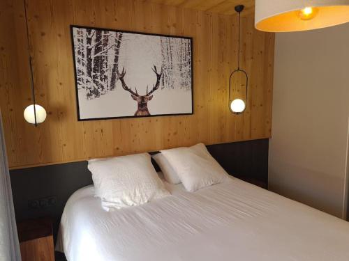 - une chambre dotée d'un lit avec une photo de cerf sur le mur dans l'établissement Appartement 6 à 8 voyageurs, à Huez