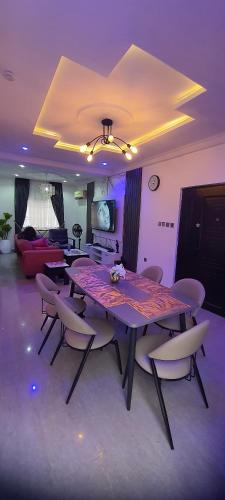 a dining table and chairs in a living room at Legend's Court by Daisy's Inn in Lekki