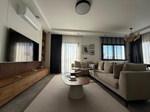 a living room with a couch and a flat screen tv at Zephyros in Alsancak