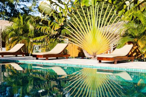 a swimming pool with two lounge chairs and palm trees at A Piscina Itaca in Barrinha