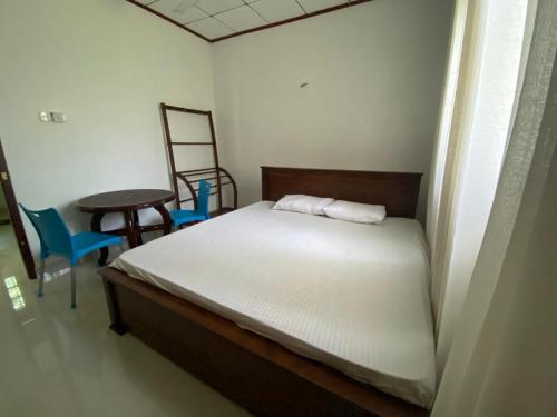 Un dormitorio con una cama y una mesa y sillas. en Gama villa, en Ahangama