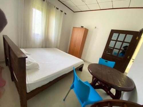 Un dormitorio con una cama y una mesa y sillas. en Gama villa, en Ahangama