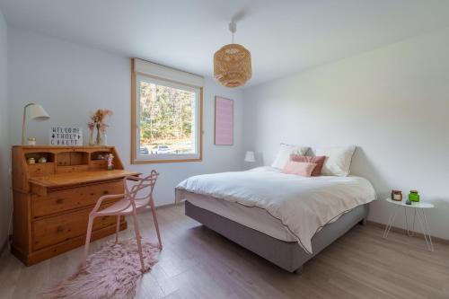a bedroom with a bed and a desk and a window at Le Petit Chalet - Vue montagne in Le Tholy