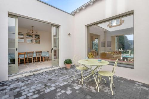 une terrasse avec une table et des chaises ainsi qu'une salle à manger dans l'établissement Belle maison - 300m des marais - 950m de la plage, à Batz-sur-Mer