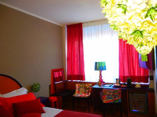 a bedroom with a bed and a window with red curtains at Delle Nazioni Milan Hotel in Milan
