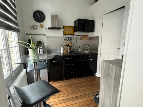 une petite cuisine avec une table en verre et un évier dans l'établissement LA FAYETTE, à Reims