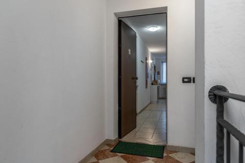 a hallway with a door with a green mat on the floor at Casa Stablum in Malè