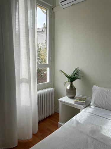 a bedroom with a bed and a window with a plant at Hotel La Mota by Punta25 Hotels Group in Medina del Campo