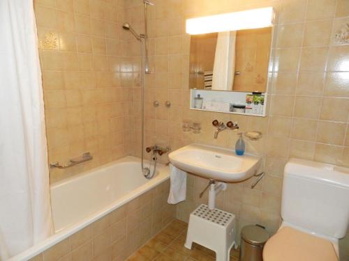 a bathroom with a sink and a tub and a toilet at Apartment Hübeli - Chapman by Interhome in Zweisimmen