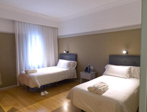 Una habitación de hotel con dos camas y una ventana. en Hotel Ciudad del Sol, en Écija