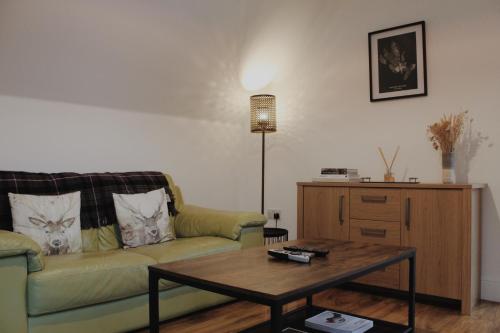 a living room with a couch and a coffee table at One Bedroom Apartment - Carbost - Skye in Carbost