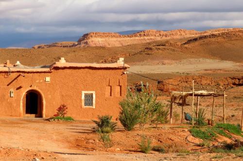 an old red brick building in the desert at Tigmi Hamid Découverte des traditions et de la culture berbère in Aït Ben Haddou