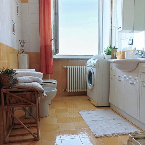 a bathroom with a washing machine and a sink at Quick Home Mimosa in Alice Castello