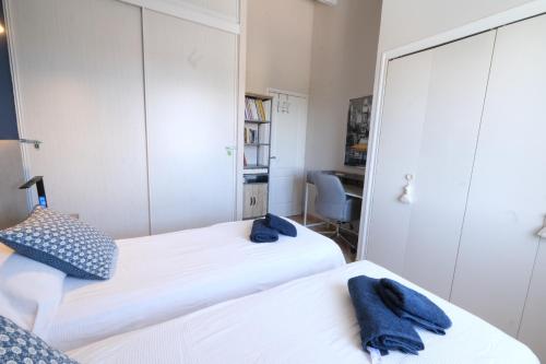 two beds in a bedroom with two blue towels at Vacation rental in the Alpilles, Provence, close to the village center - Beautiful view -Air conditionning Heated pool and spa - sleeps 8 in Aureille
