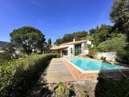 une villa avec piscine et une maison dans l'établissement Villa Lougabie pour 8 personnes, vue mer et piscine sur le Domaine de Valcros à La Londe-Les Maures, à La Londe-les-Maures