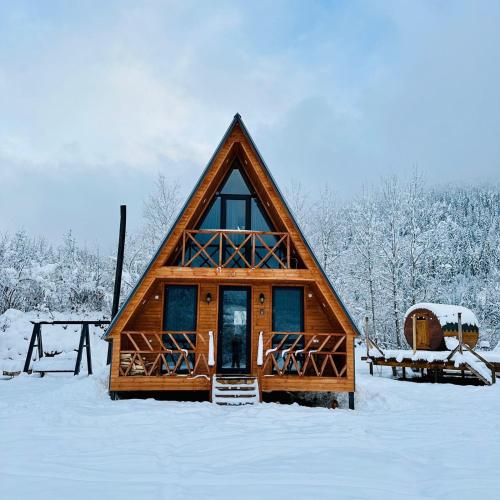 a log cabin in the snow with snow covered trees at Villa Wood in Mestia N 2 in Mestia
