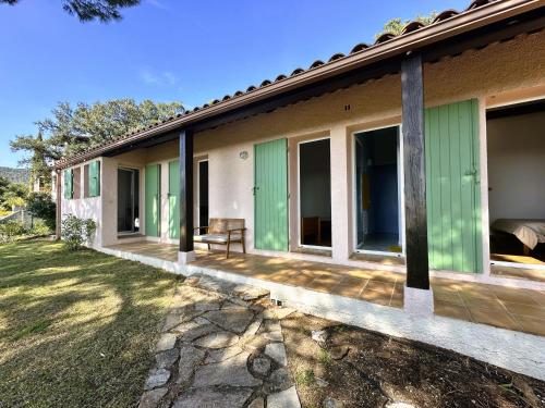 Cette maison dispose de portes vertes et d'une terrasse. dans l'établissement Villa Lougabie pour 8 personnes, vue mer et piscine sur le Domaine de Valcros à La Londe-Les Maures, à La Londe-les-Maures